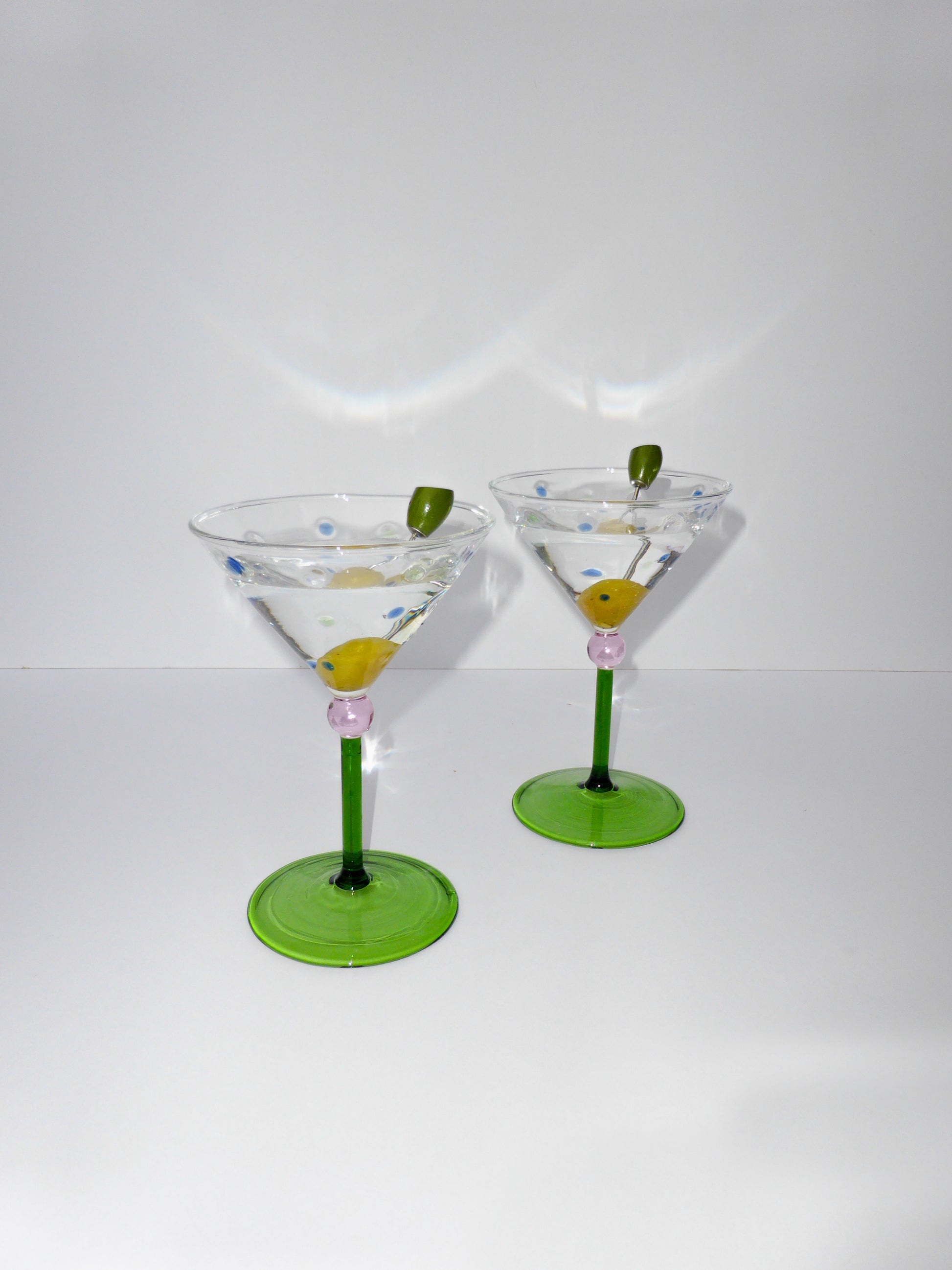 front facing image of two martini glasses with green stem and colourful polka dot detailing  